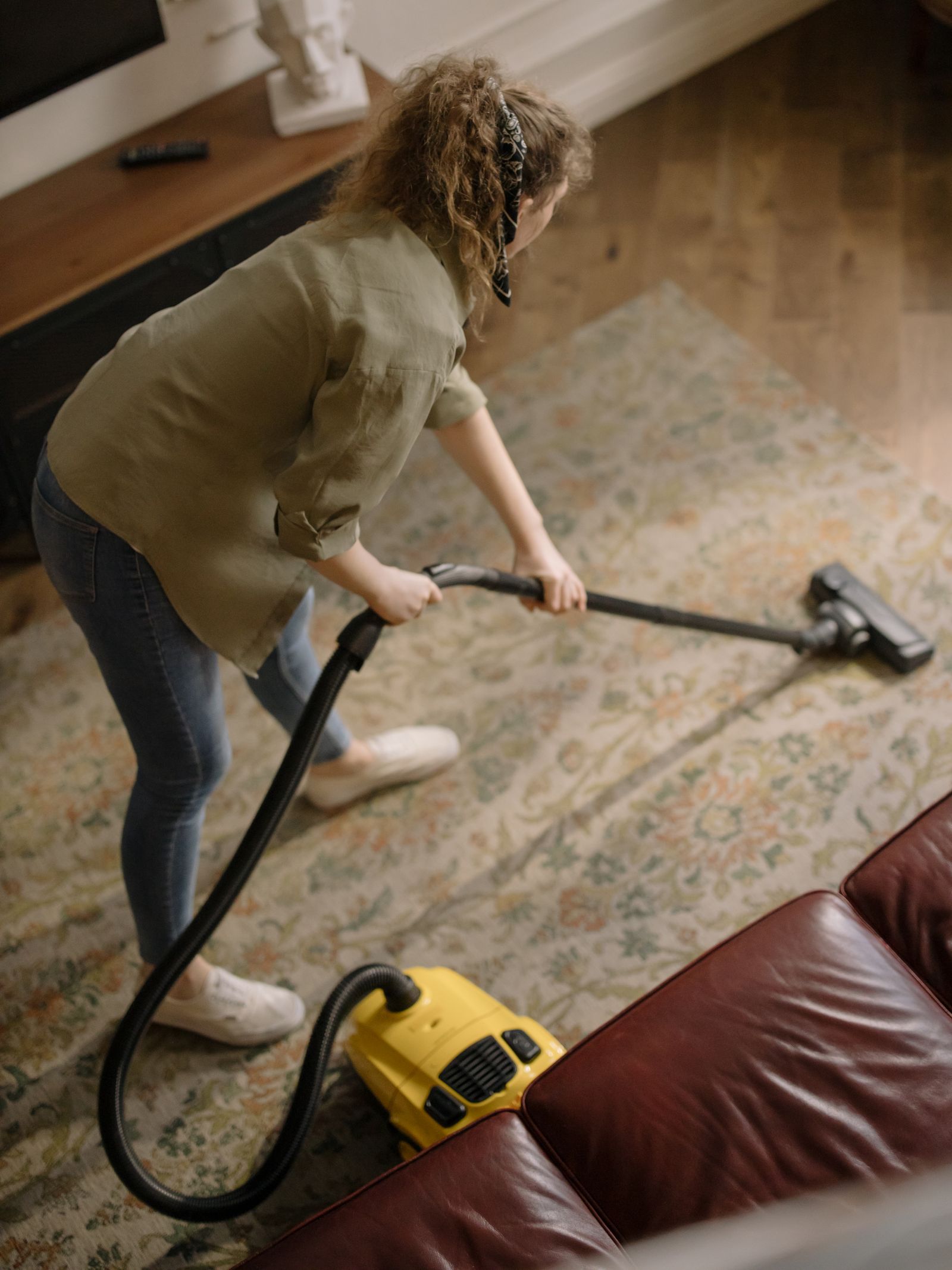 Professional vacuuming a patterned carpet in a living room