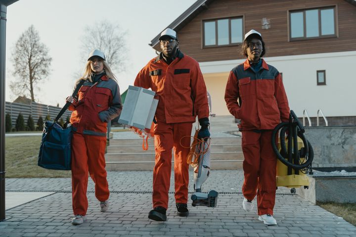 Professional cleaning team walking to a job carrying equipment