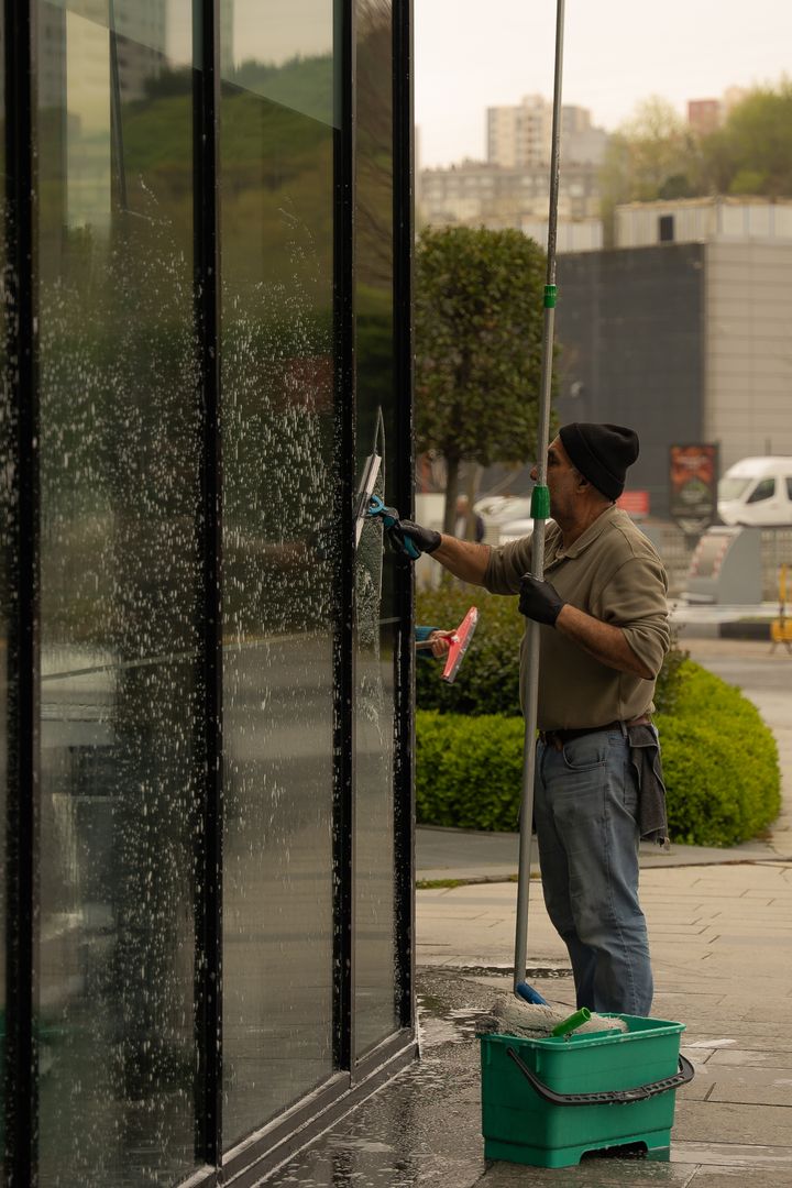 Window cleaner using a squeegee on a shopfront window